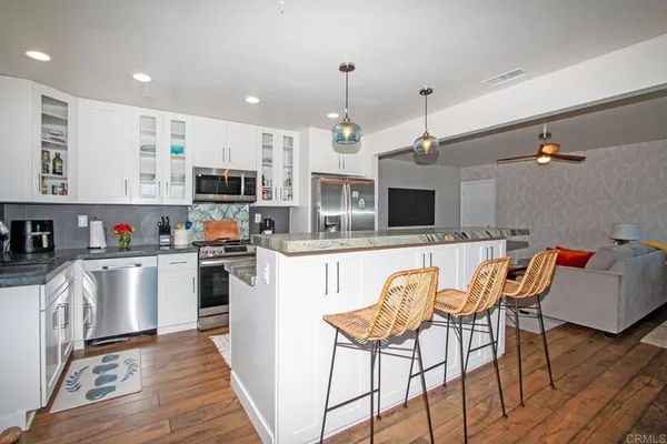 a kitchen with stainless steel appliances granite countertop a sink and a wooden floors