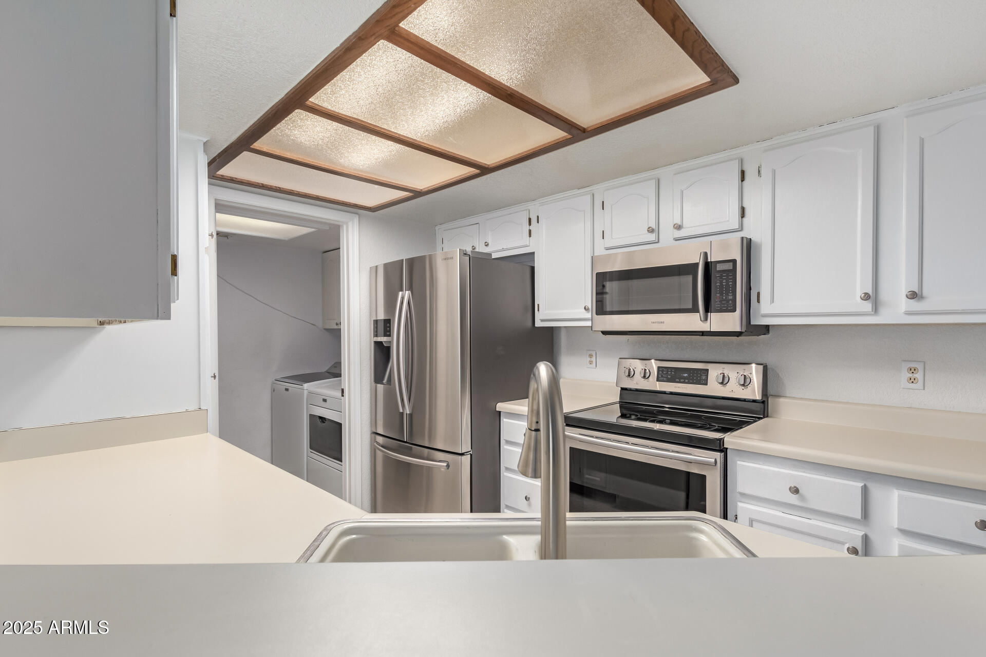 15439 North 1st Street Phoenix, AZ 85022 - Photo 9 of 26 a kitchen with stainless steel appliances a refrigerator a stove and white cabinets
