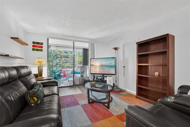 a living room with furniture flat screen tv and window
