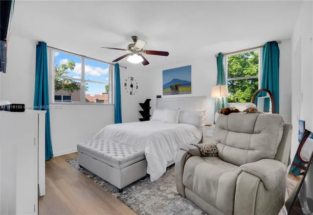 a bedroom with furniture and a large window