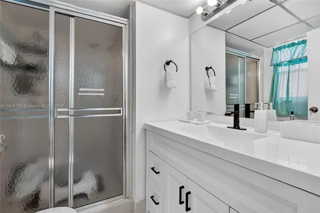 a bathroom with a shower sink and mirror