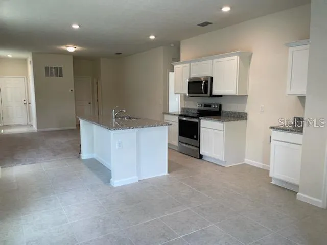 a kitchen with stainless steel appliances kitchen island sink refrigerator and stove