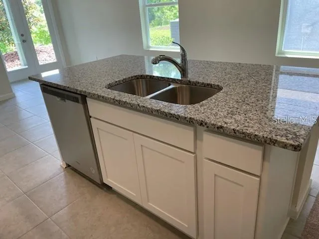 a kitchen with granite countertop a sink and a window