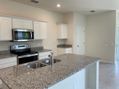 2332 Litchfield Loop DeLand, FL 32720 - Photo 5 of 15 a kitchen with a stove and a white cabinets