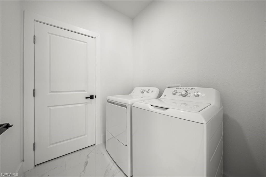 3315 67th Street West Lehigh Acres, FL 33971 - Photo 13 of 38 Laundry room with light marble finish floors and washer and dryer