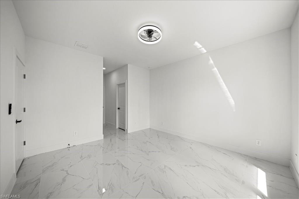 3315 67th Street West Lehigh Acres, FL 33971 - Photo 15 of 38 Spare room featuring light marble finish flooring and baseboards