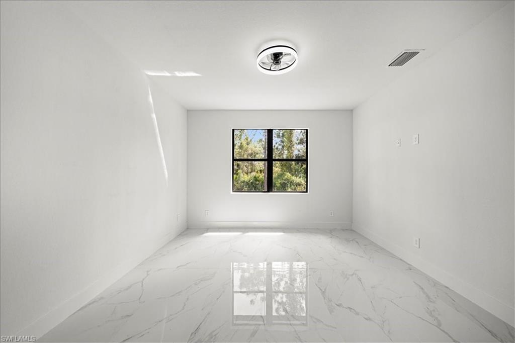 3315 67th Street West Lehigh Acres, FL 33971 - Photo 16 of 38 Spare room featuring light marble finish floors and baseboards