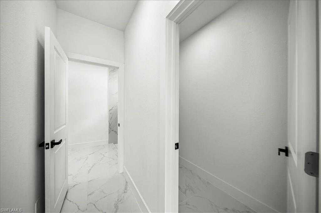3315 67th Street West Lehigh Acres, FL 33971 - Photo 17 of 38 Corridor with light marble finish flooring and baseboards
