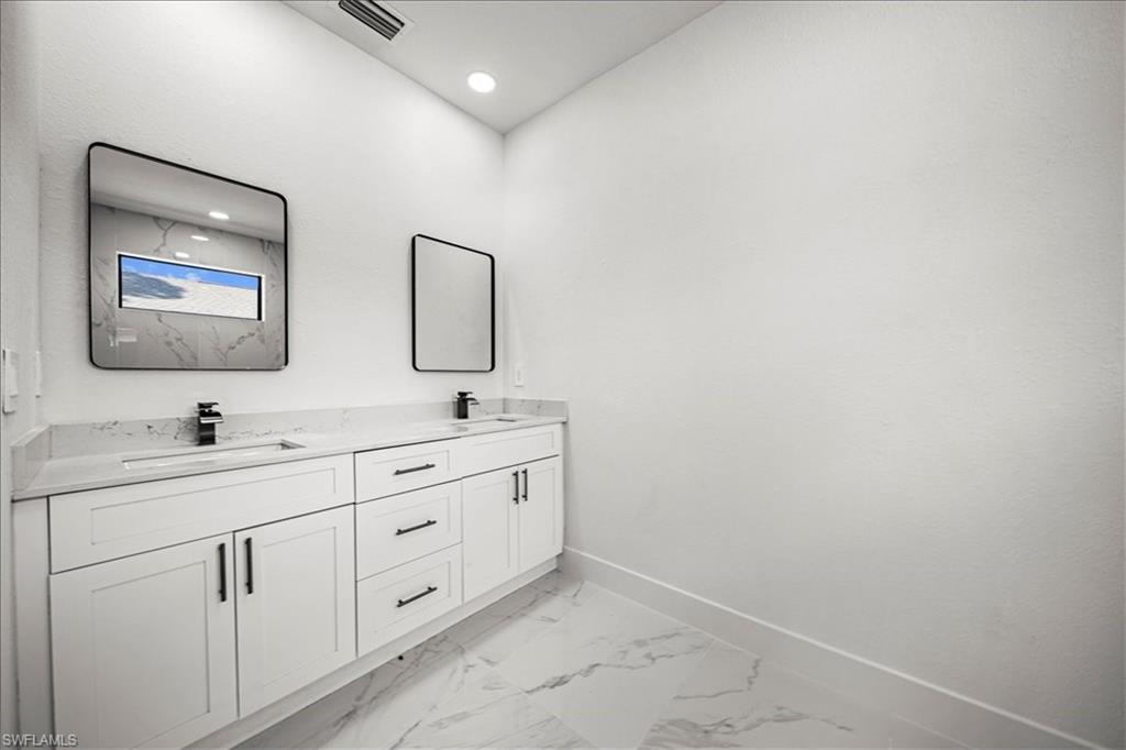 3315 67th Street West Lehigh Acres, FL 33971 - Photo 18 of 38 Bathroom featuring double vanity and light marble finish flooring