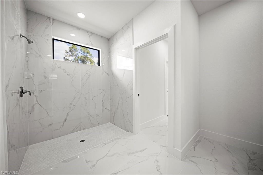 3315 67th Street West Lehigh Acres, FL 33971 - Photo 21 of 38 Full bath with light marble finish flooring, a marble finish shower, and recessed lighting