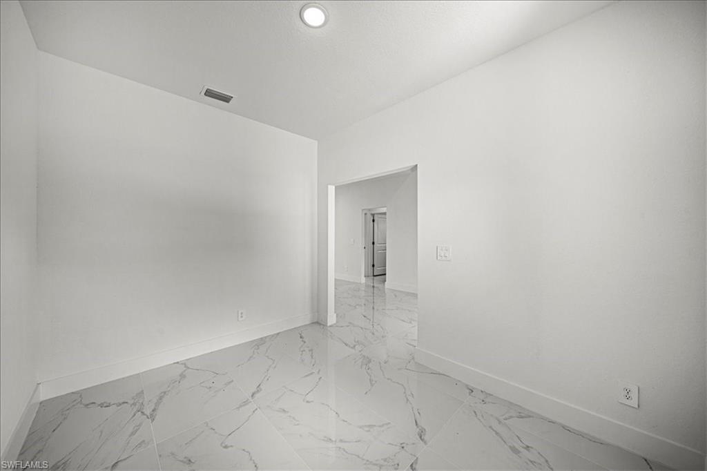 3315 67th Street West Lehigh Acres, FL 33971 - Photo 22 of 38 Empty room with baseboards and light marble finish flooring