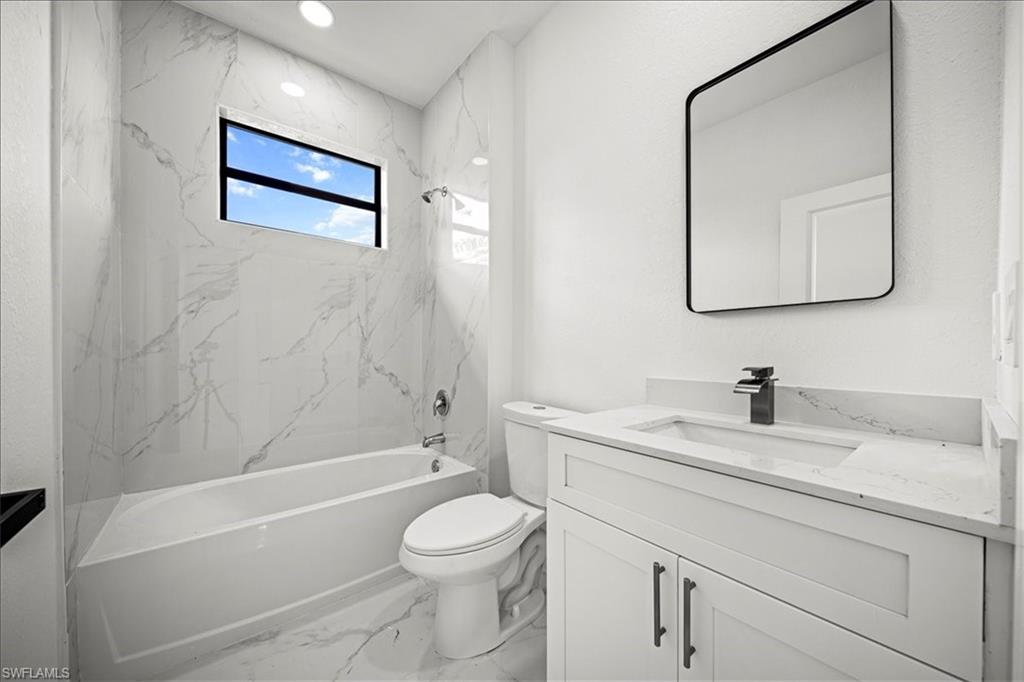 3315 67th Street West Lehigh Acres, FL 33971 - Photo 24 of 38 Bathroom with shower / bath combination, light marble finish flooring, vanity, and recessed lighting