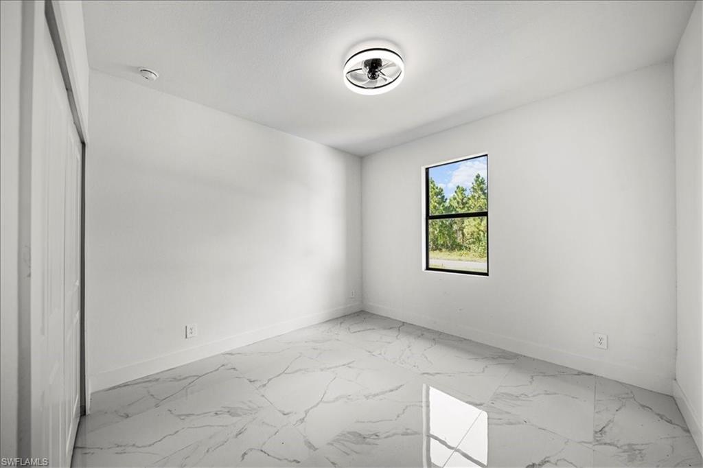 3315 67th Street West Lehigh Acres, FL 33971 - Photo 27 of 38 Unfurnished room with light marble finish flooring and baseboards