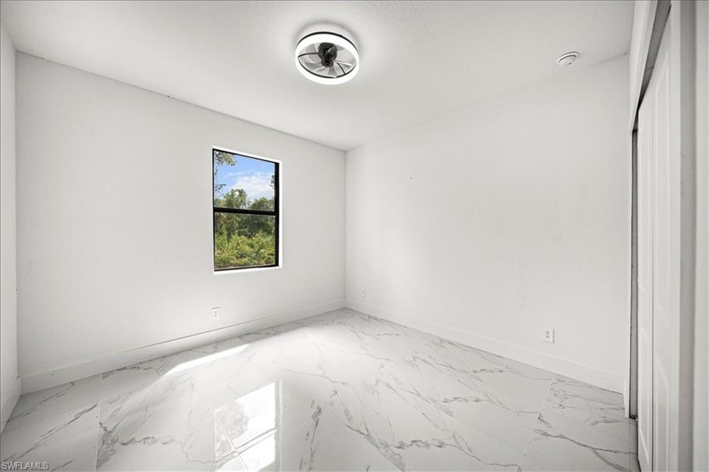 3315 67th Street West Lehigh Acres, FL 33971 - Photo 29 of 38 Unfurnished room featuring light marble finish flooring and baseboards