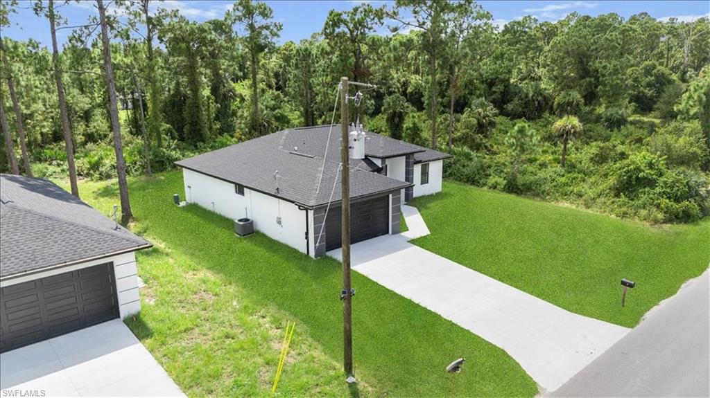 3315 67th Street West Lehigh Acres, FL 33971 - Photo 35 of 38 Aerial view of property and surrounding area featuring a forest