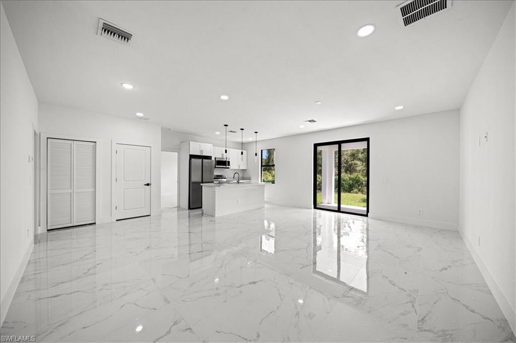 3315 67th Street West Lehigh Acres, FL 33971 - Photo 6 of 38 Unfurnished living room featuring light marble finish flooring and recessed lighting