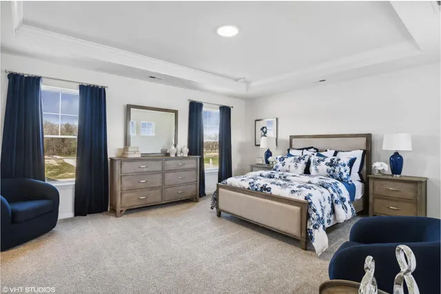 a spacious bedroom with a bed a couch and dresser