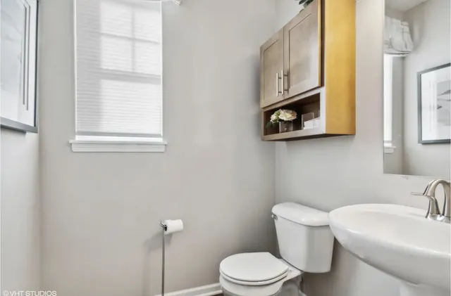 a white toilet sitting next to a bathroom sink