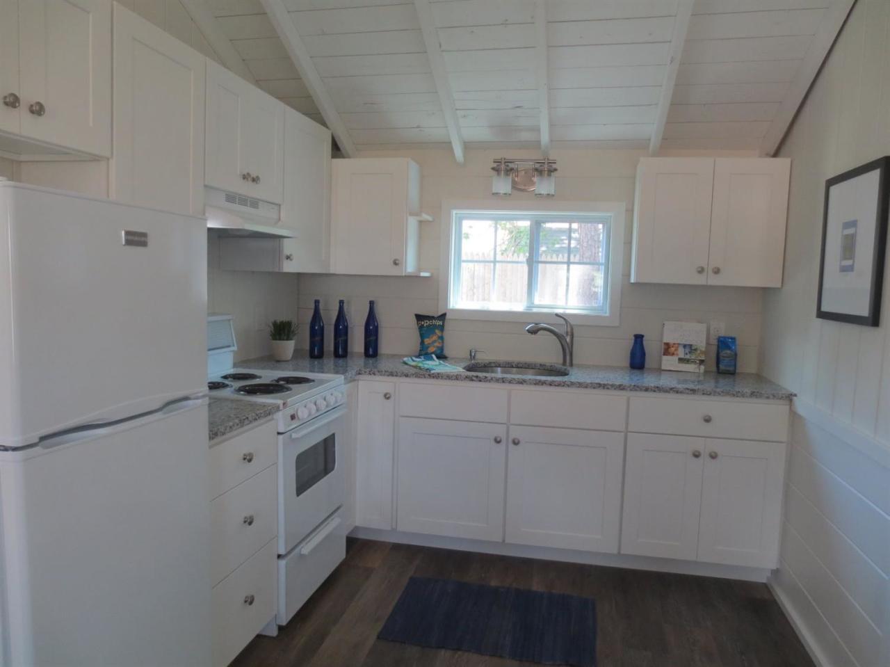 248 Old Wharf Road, Unit E2 Dennis Port, MA 02639 - Photo 13 of 27 a kitchen with granite countertop white cabinets sink and white appliances