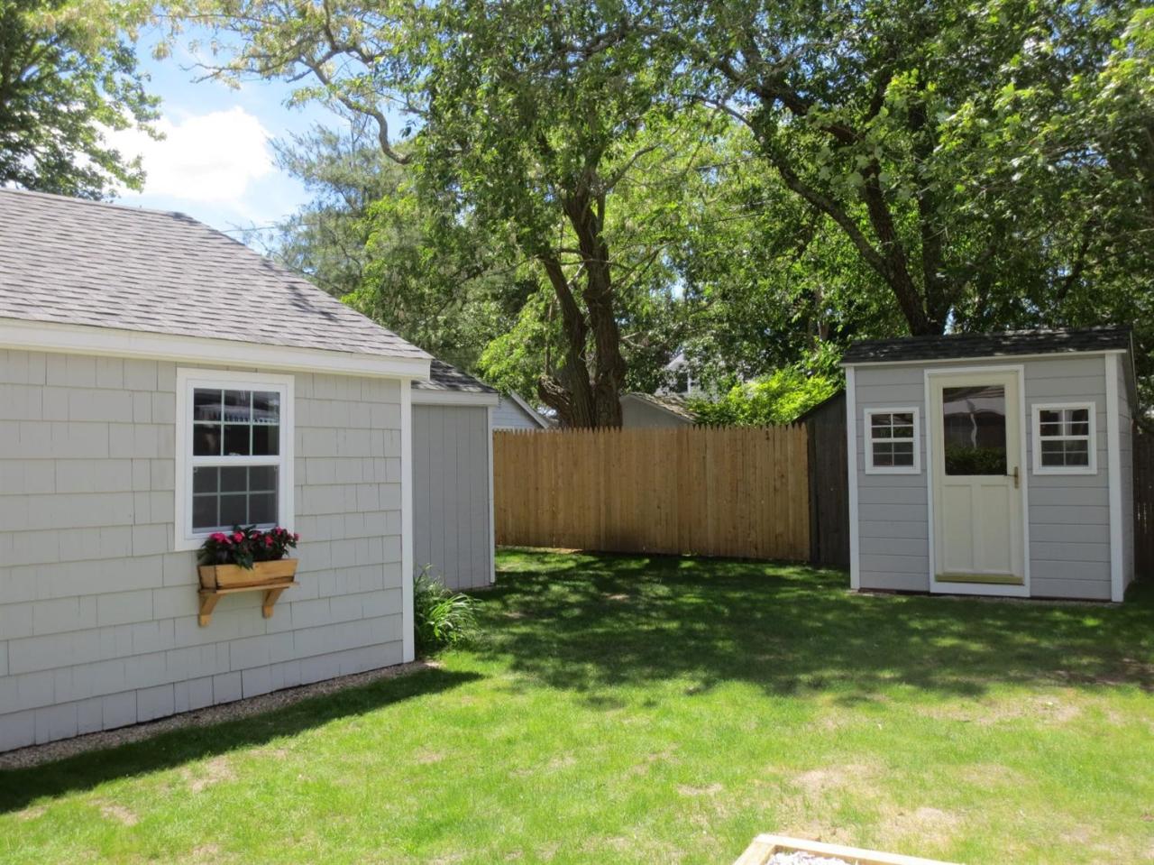 248 Old Wharf Road, Unit E2 Dennis Port, MA 02639 - Photo 22 of 27 a front view of house with yard and trees in the background