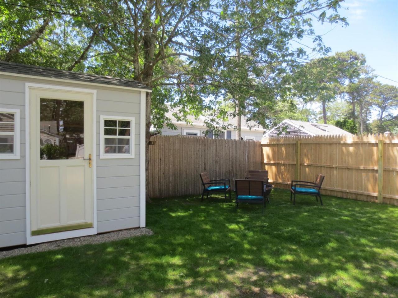 248 Old Wharf Road, Unit E2 Dennis Port, MA 02639 - Photo 23 of 27 a backyard of a house with table and chairs
