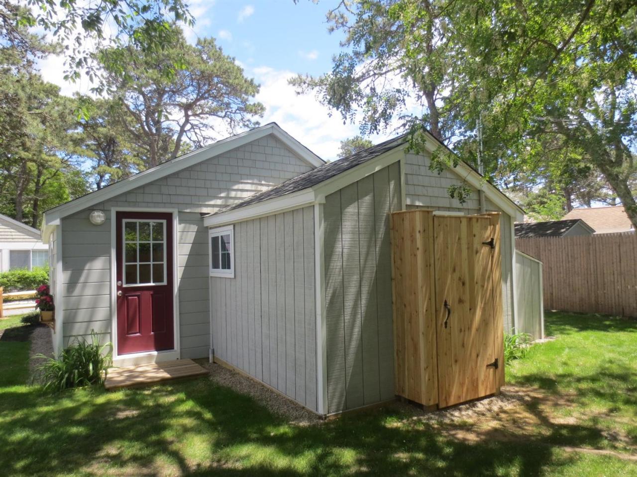 248 Old Wharf Road, Unit E2 Dennis Port, MA 02639 - Photo 24 of 27 a view of a backyard with potted plants and large tree