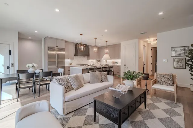 a living room with furniture and a view of kitchen