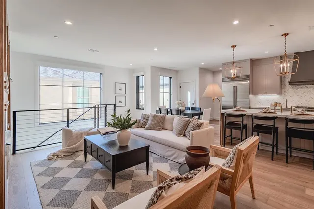 a living room with furniture kitchen and a wooden floor
