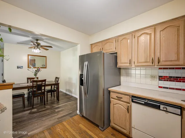 a kitchen with stainless steel appliances white cabinets and wooden floor