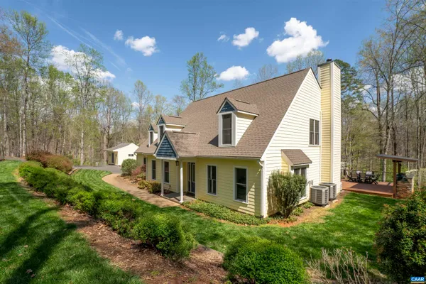 a view of a house with a yard and potted plants