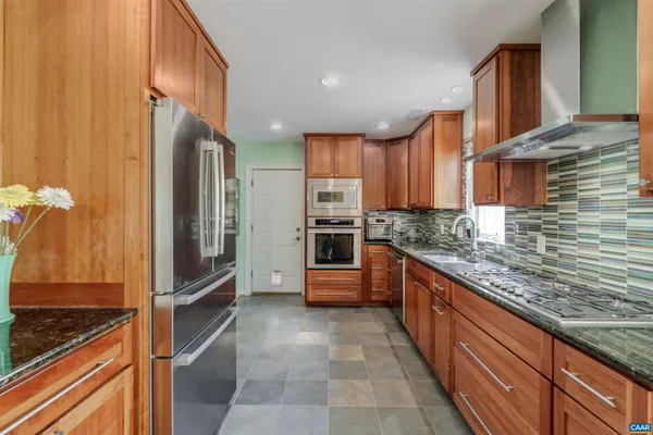 a kitchen with granite countertop a sink and a large mirror