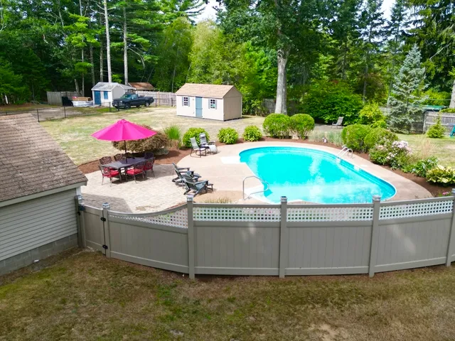 a view of backyard with swimming pool and outdoor seating
