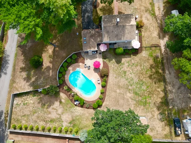an aerial view of a house with a swimming pool and a yard
