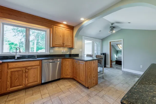 a large kitchen with stainless steel appliances granite countertop a refrigerator and a sink