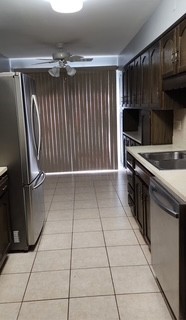 7730 Dempster Street, Unit 209 Morton Grove, IL 60053 - Photo 16 of 32 a kitchen with a wooden cabinets and a stove top oven