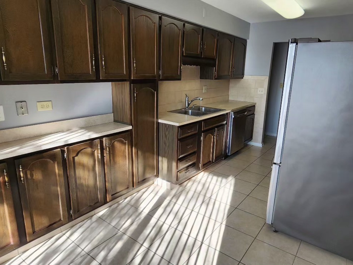 7730 Dempster Street, Unit 209 Morton Grove, IL 60053 - Photo 19 of 32 a kitchen with a refrigerator and a sink
