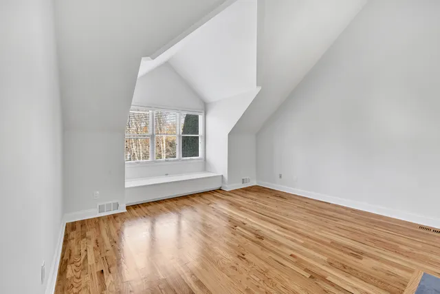 a view of kitchen with stainless steel appliances wooden floor and large window