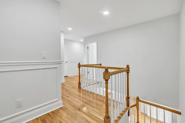 an empty room with wooden floor and stairs