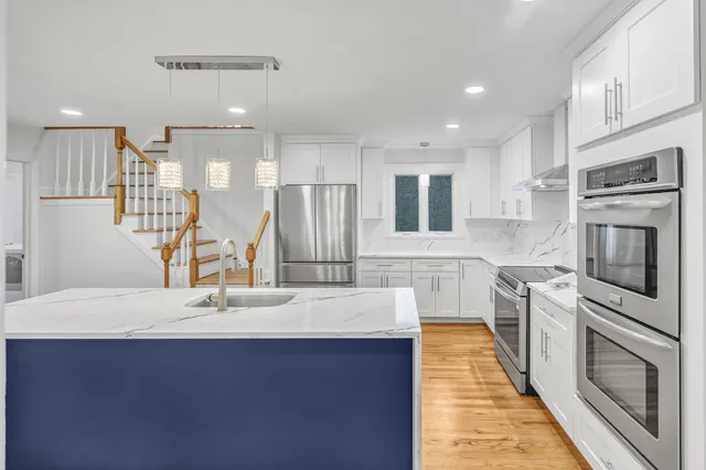 a kitchen with stainless steel appliances a sink stove and refrigerator