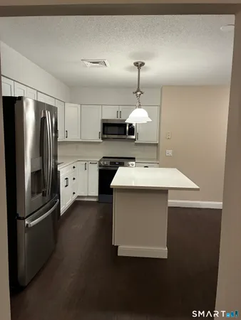 a kitchen with a sink stainless steel appliances and white cabinets