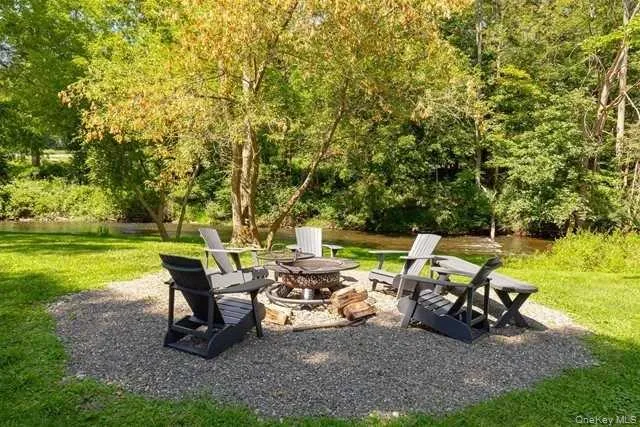 a view of a big yard with table and chairs under an umbrella