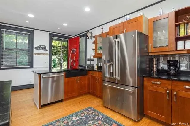 a kitchen with stainless steel appliances granite countertop a refrigerator a stove and a sink