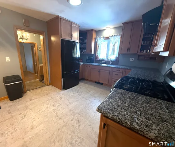a kitchen with stainless steel appliances granite countertop a refrigerator a stove and a sink