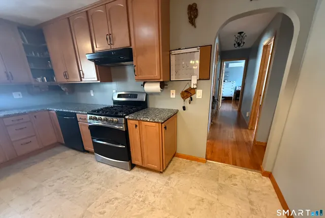 a kitchen with stainless steel appliances granite countertop a stove a sink and a refrigerator