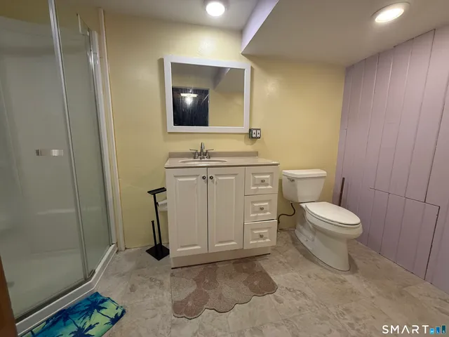a bathroom with a toilet a sink and mirror