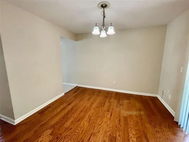 a view of a room with wooden floor and ceiling fan