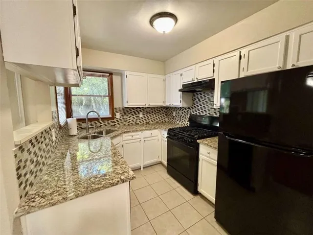 a kitchen with a sink a stove and a microwave