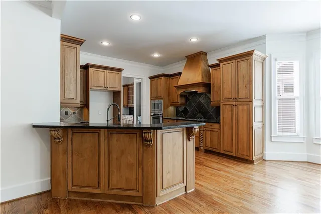 a kitchen with stainless steel appliances granite countertop a stove and a wooden floors