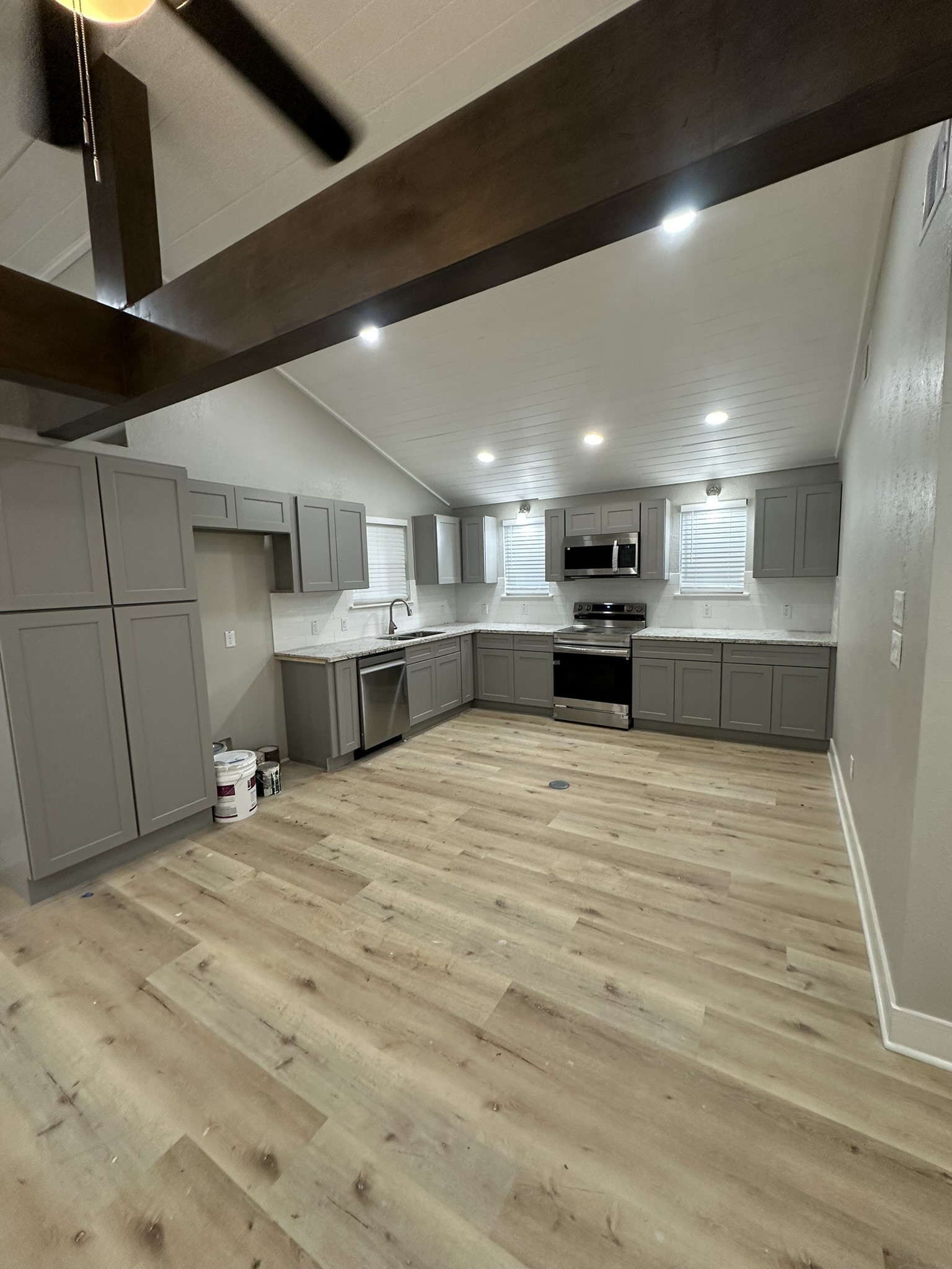 8223 Wallis Street Fulshear, TX 77441 - Photo 17 of 30 a large kitchen with a large counter top stainless steel appliances and a chandelier
