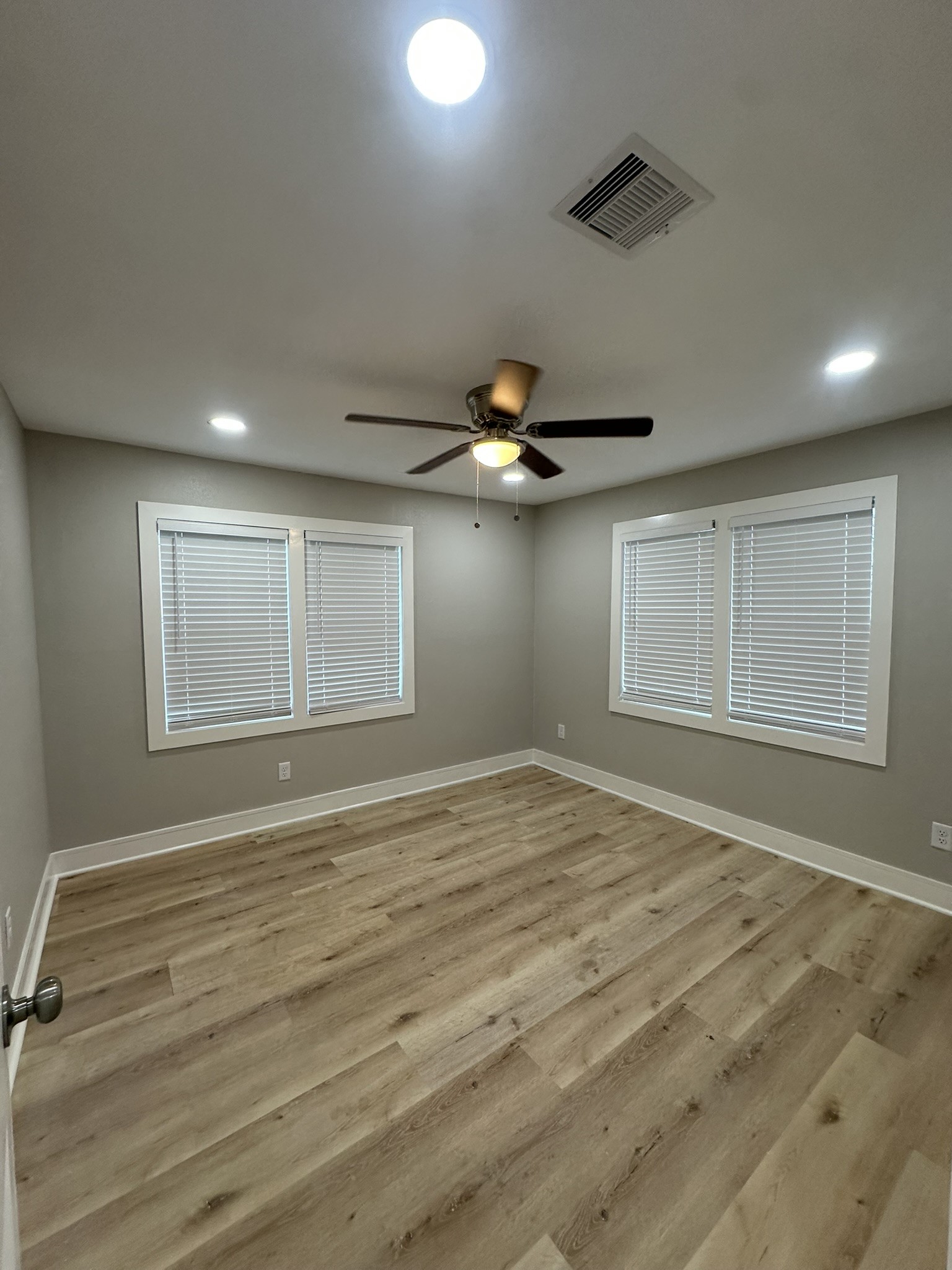 8223 Wallis Street Fulshear, TX 77441 - Photo 20 of 30 a view of an empty room with wooden floor and a ceiling fan